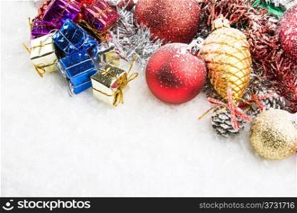 christmas accessories, gift boxes and spheres on snow
