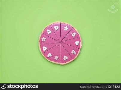 Christmas Advent context with a pink chocolate pie slices with numbers on it. Chocolate tart on green table. Numbered pie slices. Limited pie pieces.