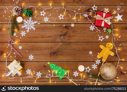 christmas and holidays concept - electric garland and decorations on wooden background. christmas gifts and decorations on wooden boards