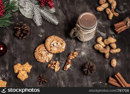 Christmas and new year celebration table decoration background with garland, cookies, pine cones, wallnuts and candle in cup. Christmas and new year table decoration background with garland, cookies, pine cones, wallnuts and candle in cup