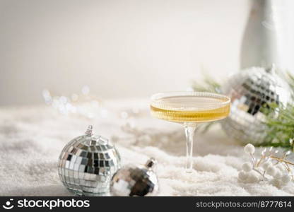 Christmas and New Year celebration with champagne. New Year holiday decorated table. Festive New Year champagne and silver baubles. Close up. Christmas greeting card with copy space.. Festive New Year champagne