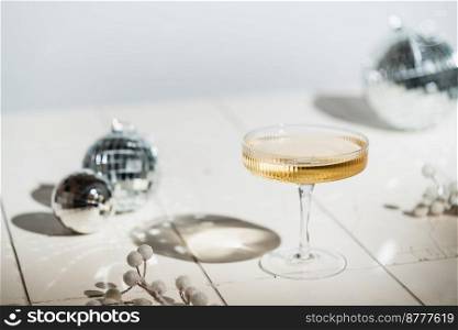 Christmas and New Year celebration with champagne. New Year holiday decorated table. Festive New Year champagne and silver baubles. Close up. Christmas greeting card with copy space.. Festive New Year champagne