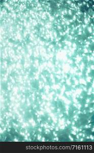 Christmas and New Year holiday neo mint, biscay green Glitter Shimmering festive abstract texture background with bokeh defocused lights