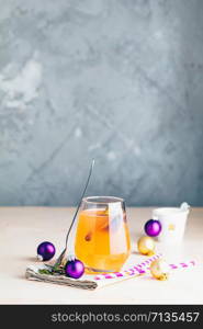 Christmas and New Year pink cocktail with fig and cinnamon in glass on pink concrete background, close up, surrounded holiday decor. Winter festive drinks and alcoholic cocktails or detox drink