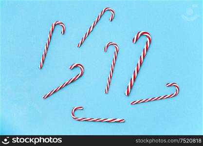 christmas and winter holidays concept - candy cane decorations on blue background. candy cane decorations on blue background