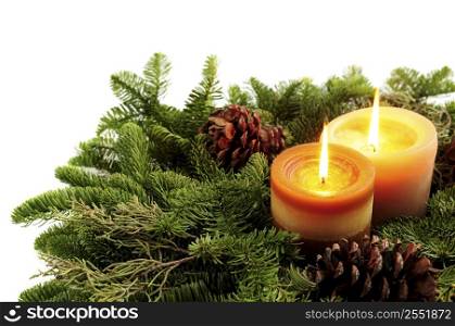 Christmas arrangement of burning candles and green spruce branches on white background
