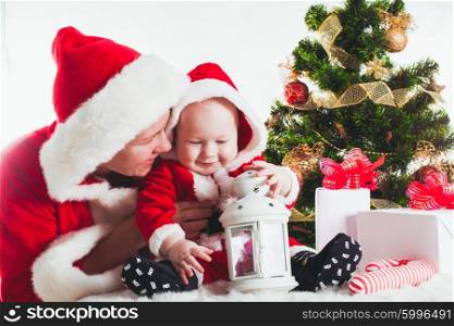 Christmas baby and mom under the fir tree isolated. Christmas baby and mom