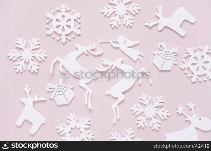 Christmas background composed of white christmas decoration: snowflakes, deers, flying angel and gift boxes on pink background. Christmas wallpaper. Flat lay composition for websites, social media, business owners, magazines, bloggers, artists etc.