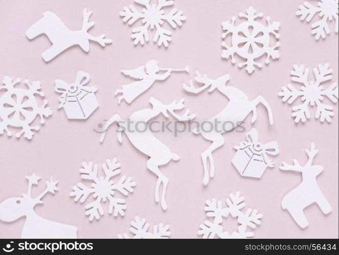 Christmas background composed of white christmas decoration: snowflakes, deers, flying angel and gift boxes on pink background. Christmas wallpaper. Flat lay composition for websites, social media, business owners, magazines, bloggers, artists etc.