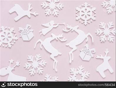 Christmas background composed of white christmas decoration: snowflakes, deers, flying angel and gift boxes on pink background. Christmas wallpaper. Flat lay composition for websites, social media, business owners, magazines, bloggers, artists etc.