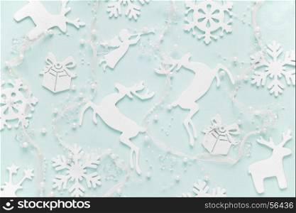 Christmas background composed of white christmas decoration: snowflakes, deers, flying angel and gift boxes on blue background. Christmas wallpaper. Flat lay composition for websites, social media, business owners, magazines, bloggers, artists etc.