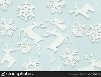 Christmas background composed of white christmas decoration: snowflakes, deers, flying angel and gift boxes on blue background. Christmas wallpaper. Flat lay composition for websites, social media, business owners, magazines, bloggers, artists etc.