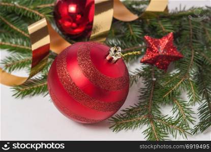 Christmas background of red balls, fir branches and ribbons of serpentine
