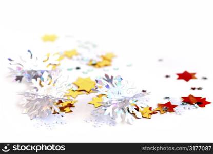 Christmas background of scattered gilittering confetti on white