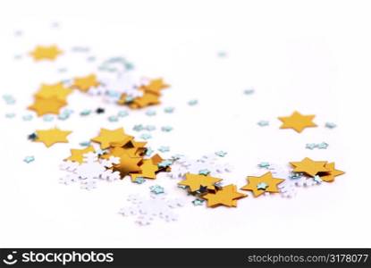 Christmas background of scattered gilittering confetti on white