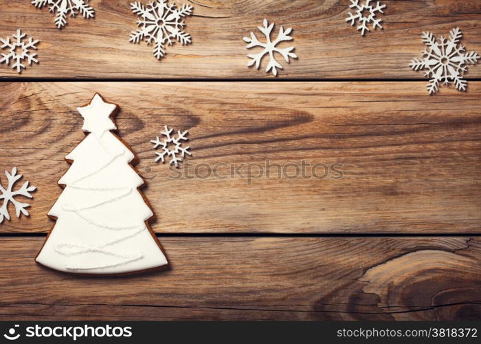 Christmas background with gingerbread cookie in shape of tree on wooden table. Copy space. Top view