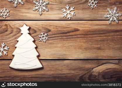 Christmas background with gingerbread cookie in shape of tree on wooden table. Copy space. Top view