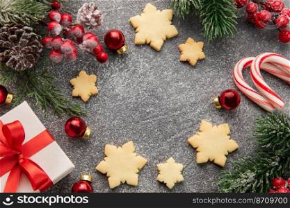 Christmas background with gingerbread cookies, gift boxe and fir branches  on darck concrete background. Winter festive concept. Flat lay, copy space.
