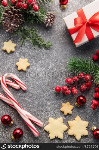 Christmas background with gingerbread cookies, gift boxe and fir branches  on darck concrete background. Winter festive concept. Flat lay, copy space.
