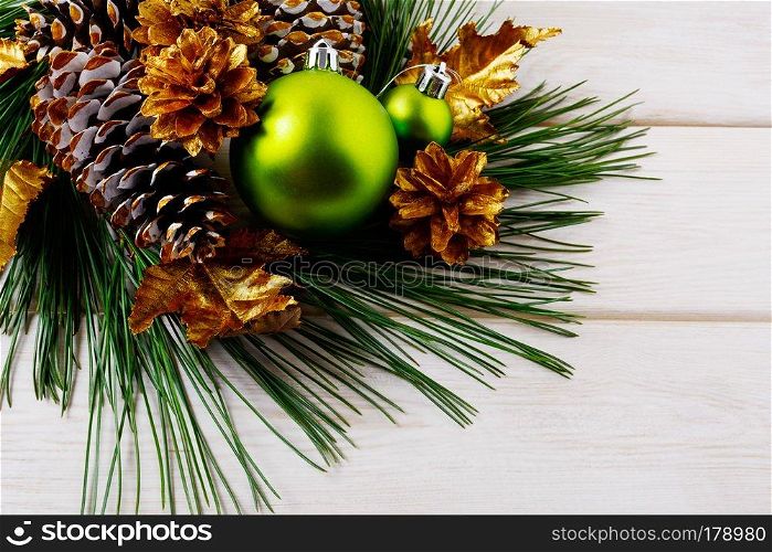 Christmas background with green ornaments and golden pine cones. Christmas party decoration.