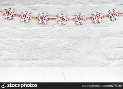 Christmas background with red felt snowflakes garland on white brick wall background. Mockup with copy space, banner, header, template New Year background. Christmas background with red felt snowflakes garland on white brick wall. Mockup with copy space