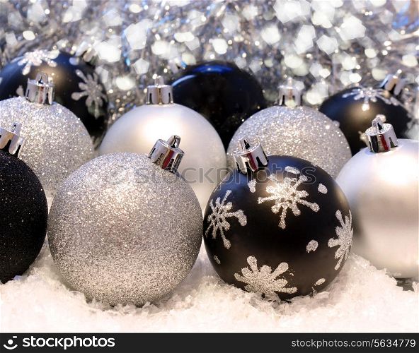 Christmas background with silver and black baubles nestled in snow