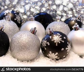 Christmas background with silver and black baubles nestled in snow