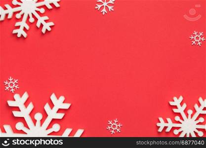 Christmas background with snowflakes on red paper. Copy space. Top view