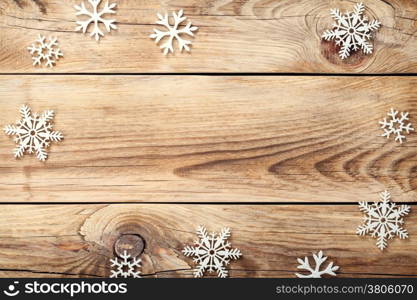 Christmas background with snowflakes on wooden table. Copy space. Top view