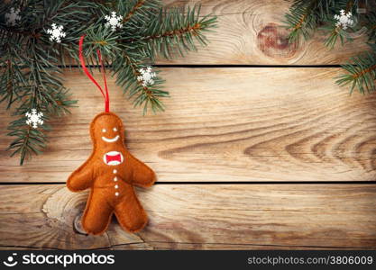 Christmas background with spruce tree and gingerbread man on wooden table. Copy space. Top view