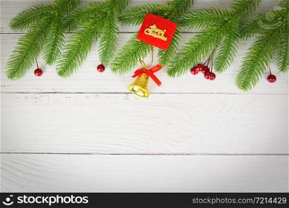 Christmas background wood composition fir branches and red berries / christmas decoration pine tree with bell festive xmas winter and Happy New Year object holiday concept , top view copy space