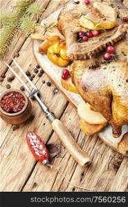 Christmas baked duck on a background of Christmas decorations.. Roasted Christmas goose.