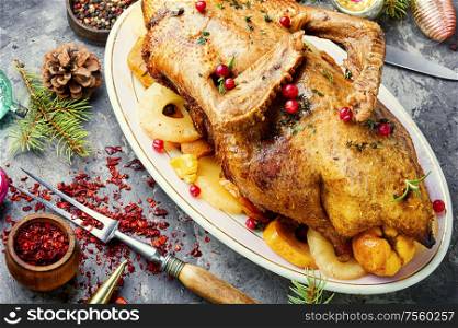 Christmas baked duck on a background of Christmas decorations.. Roasted Christmas goose.