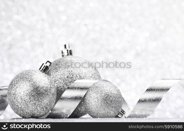 Christmas ball and curly decorative ribbon on bokeh background