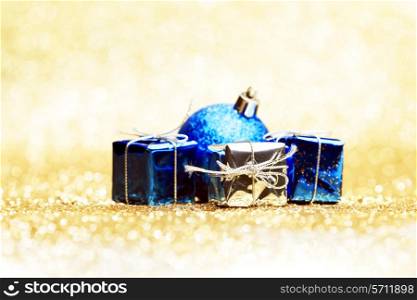 Christmas ball and gifts on abstract glitter background