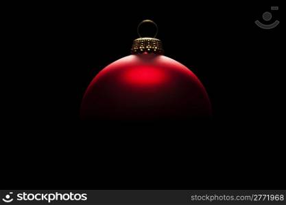 christmas ball in tense light. red christmas ball in tense light on black background