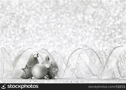 Christmas balls and ribbons decoration on shiny silver background