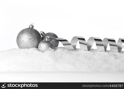 Christmas balls and ribbons on snow