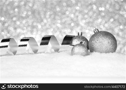 Christmas balls and ribbons on snow