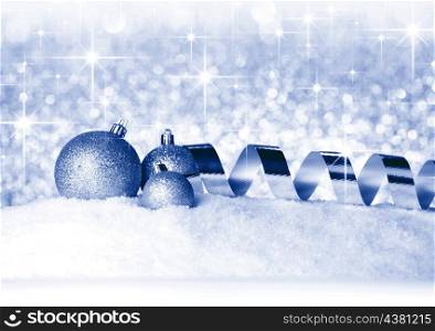 Christmas balls and ribbons on snow over shiny stars background