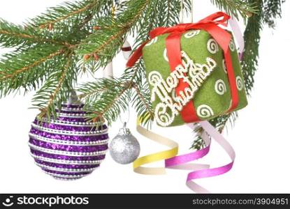 Christmas balls, gift and decoration on fir tree branch isolated on white