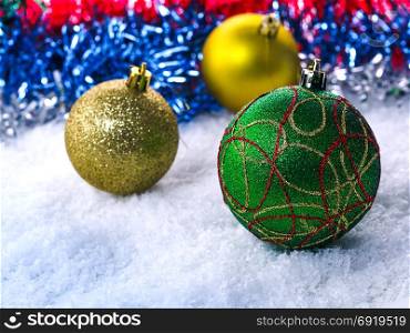 Christmas balls in snow on a blurred background. Focus on the front ball.