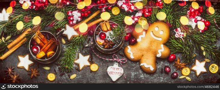 Christmas banner with Gingerbread Man, Cookies, mulled wine ,holiday decorations , fir branches and festive bokeh lighting on dark wooden background, top view