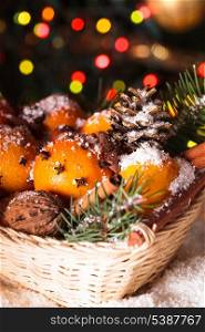 Christmas basket - fir, tangerins and spices under the snow