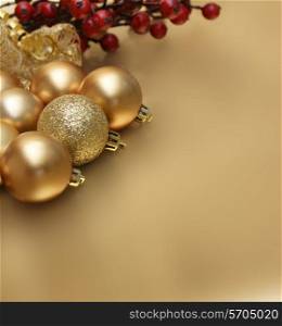 Christmas baubles and berries on a gold background