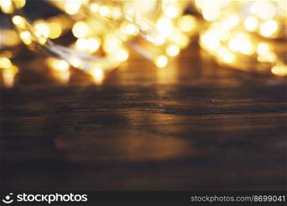 christmas beautifull shiny gold garland on a wooden brown background. sparkle festive blurred background with copy space for your text. christmas beautifull shiny gold garland on a wooden brown background. sparkle festive background