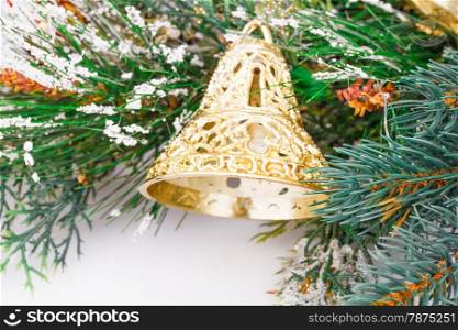 Christmas bell and fir-tree branch on gray background.