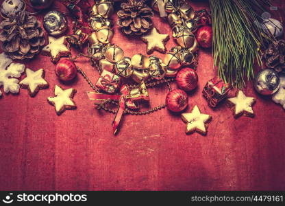 Christmas bell wreath and decorations on red wooden background, top view, border