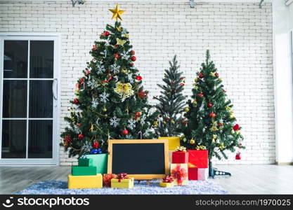 Christmas blackboard with many gifts with abstract green Christmas tree background with Copy Space,Decoration During Christmas and New Year.