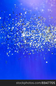 Christmas blue background. Golden holiday glowing abstract glitter defocused background
